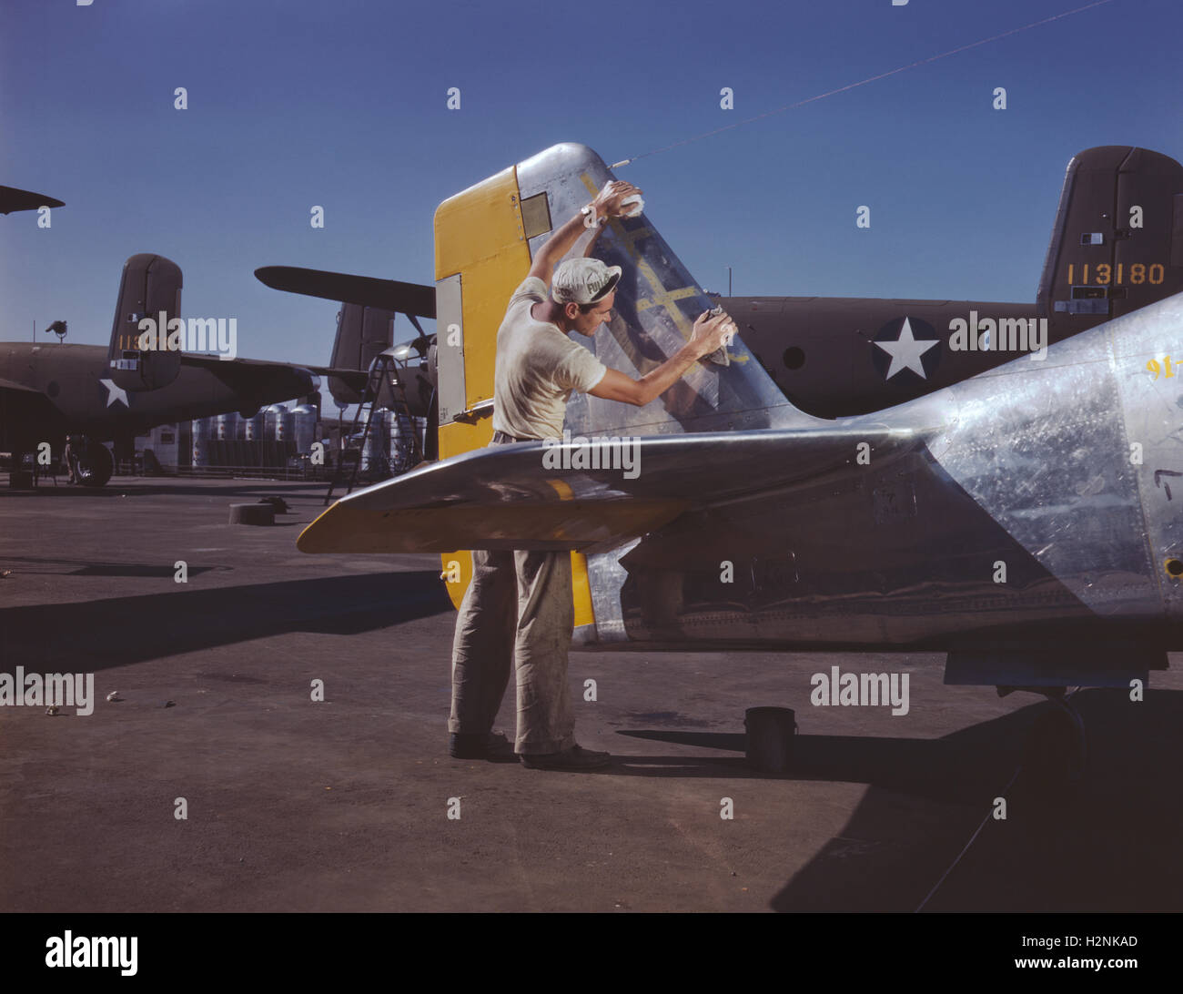 Pittore la pulizia della sezione di coda del P-51 da combattimento aereo su Outdoor linea di assemblaggio prima della spruzzatura Olive-Drab camuffamento di U.S. Esercito, la North American Aviation, Inc, Inglewood, California, USA, Alfred T. Palmer per ufficio di informazione di guerra, Ottobre 1942 Foto Stock