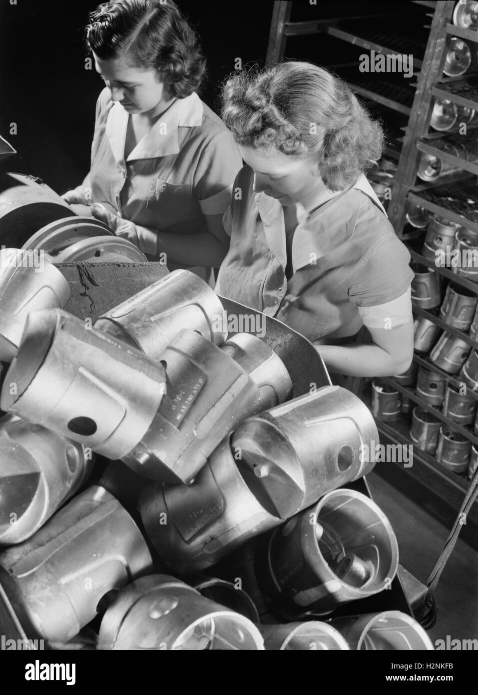 Due dei lavoratori di sesso femminile di ispezionare i pistoni Heat-Treated prima di durezza Brinnell test presso la fabbrica di alluminio convertito alla produzione bellica, alluminio Industries, Inc., Cincinnati, Ohio, Stati Uniti d'America, Alfred T. Palmer per ufficio di informazione di guerra, Febbraio 1942 Foto Stock