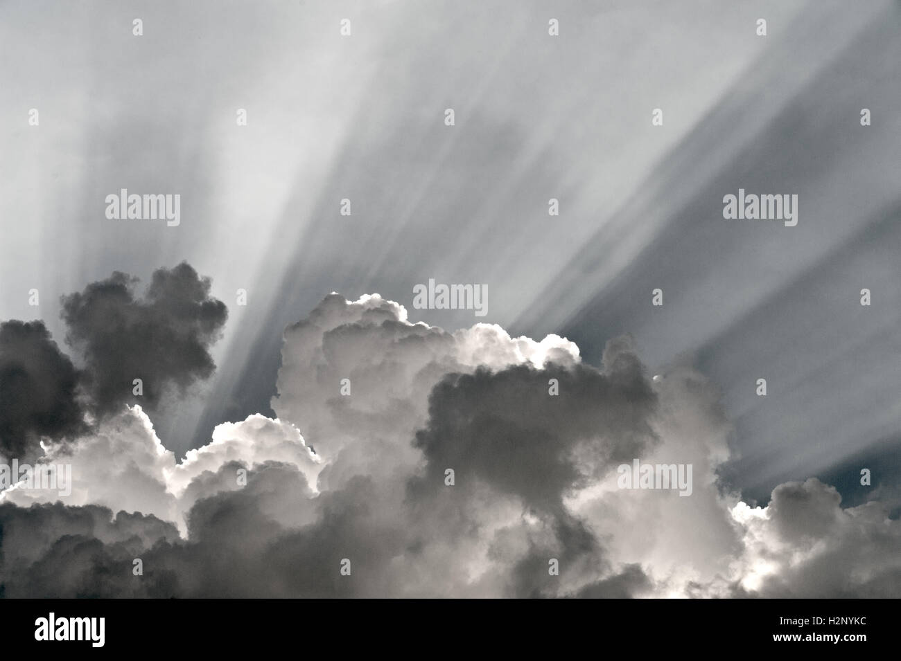 Raggi di luce dietro le nuvole scure. Foto Stock