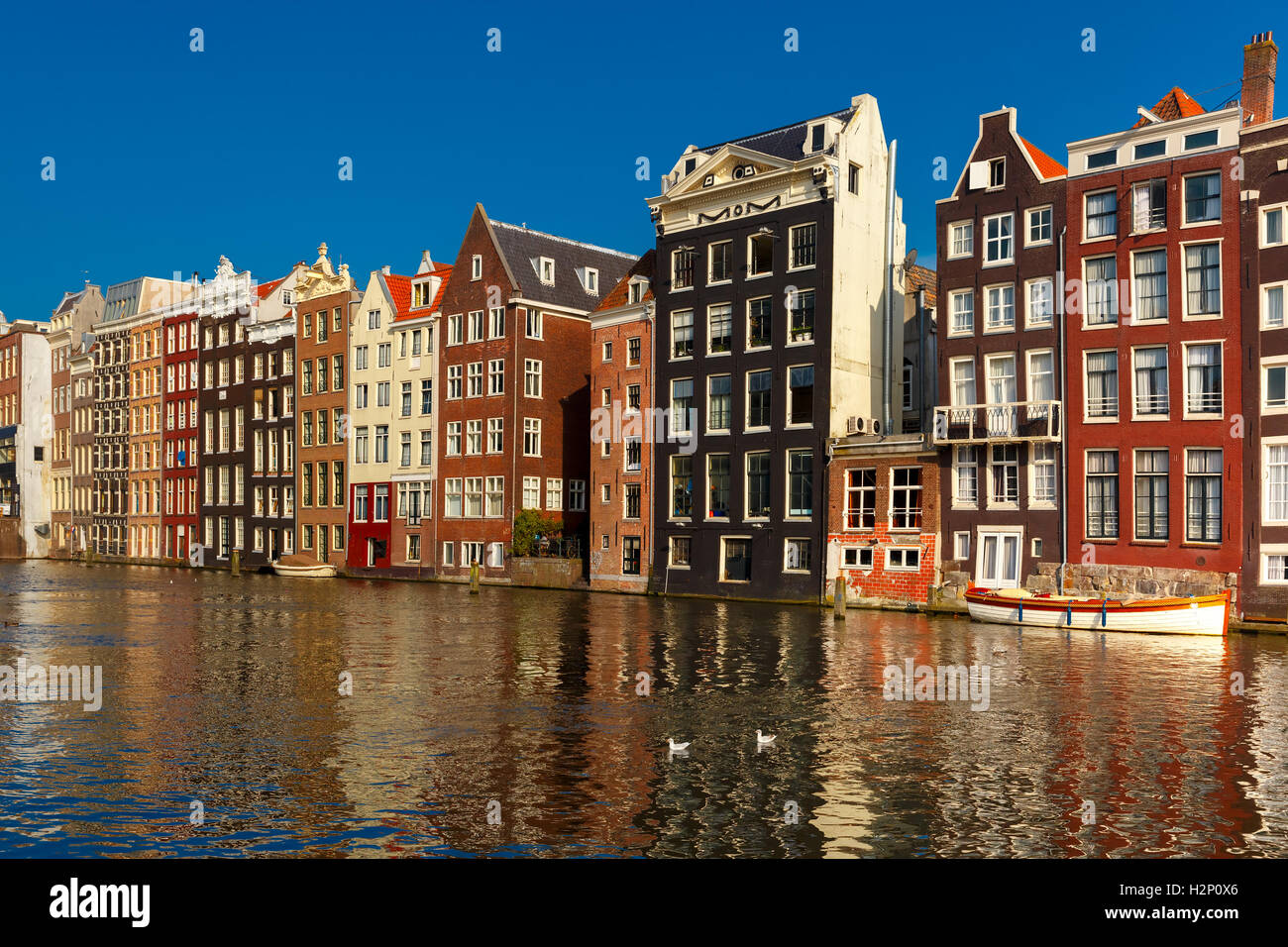 La danza di case a canale di Amsterdam Damrak, Holland, Paesi Bassi. Foto Stock