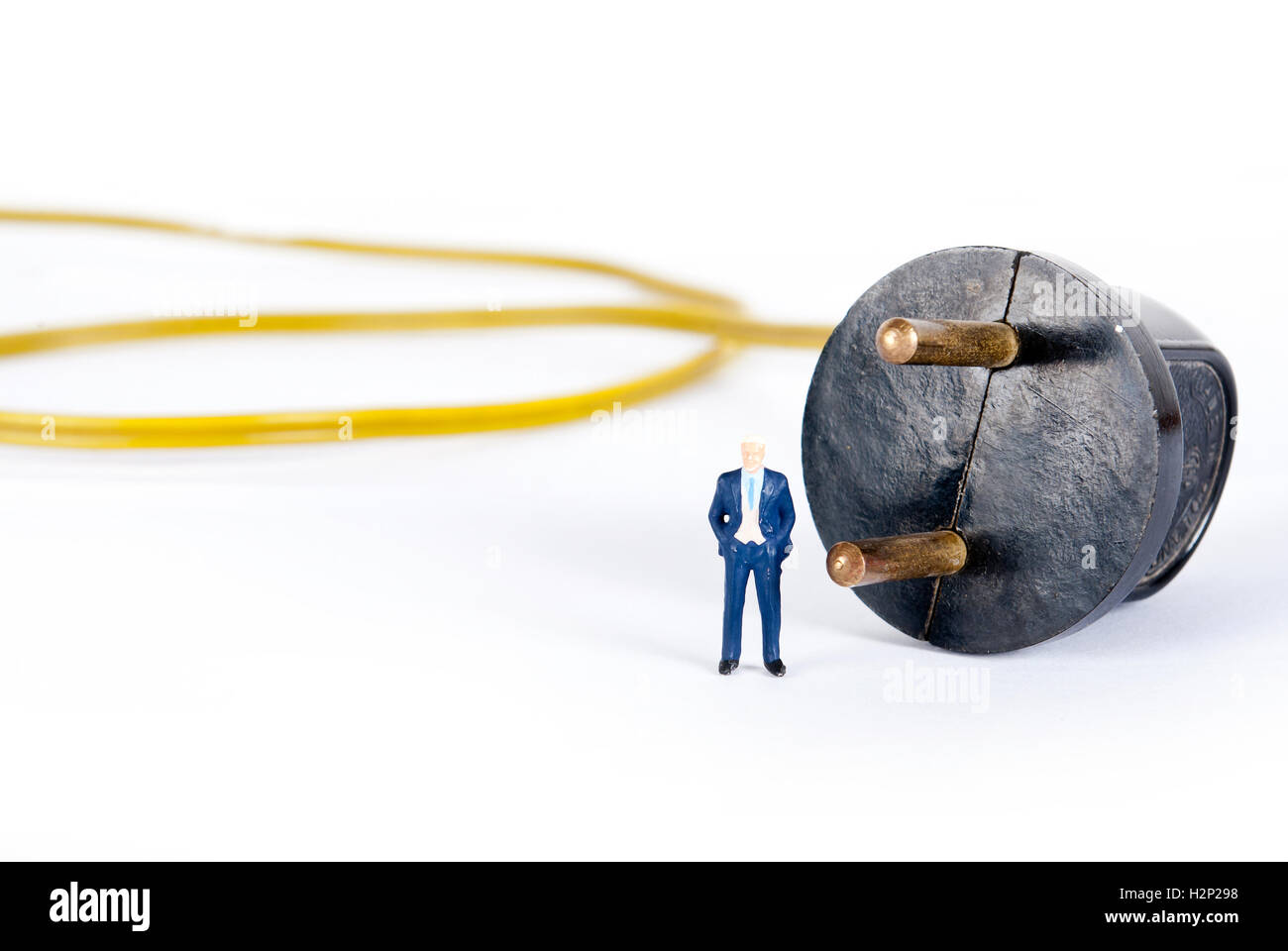 Uomo in miniatura sulla spina di alimentazione Foto Stock