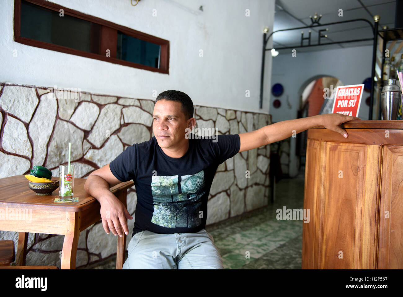 Uomo cubano è seduto in un bar locale a Santiago de Cuba, Cuba. Foto Stock