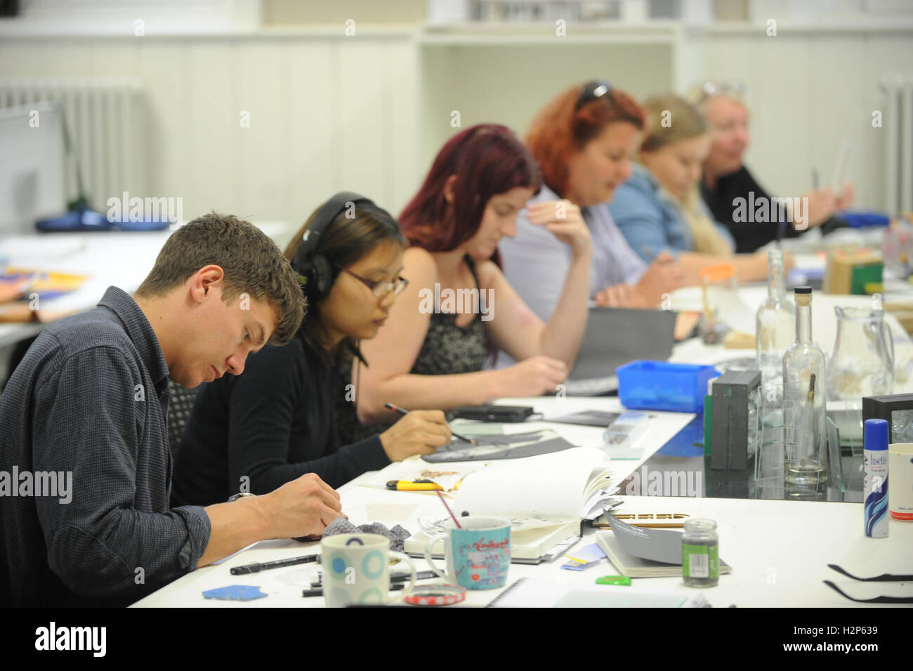 Gli studenti universitari di ottenere le loro teste verso il basso e lavorare duro per la loro educazione in un collegio di classe. Foto Stock