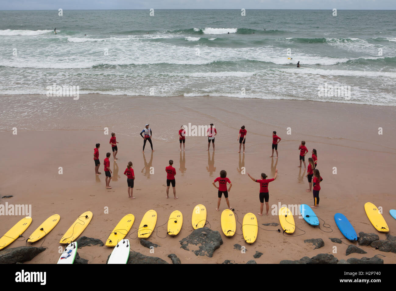 Surfers di formazione presso la Côte des Basques Beach a Biarritz, Paesi Baschi francesi, Francia. Foto Stock