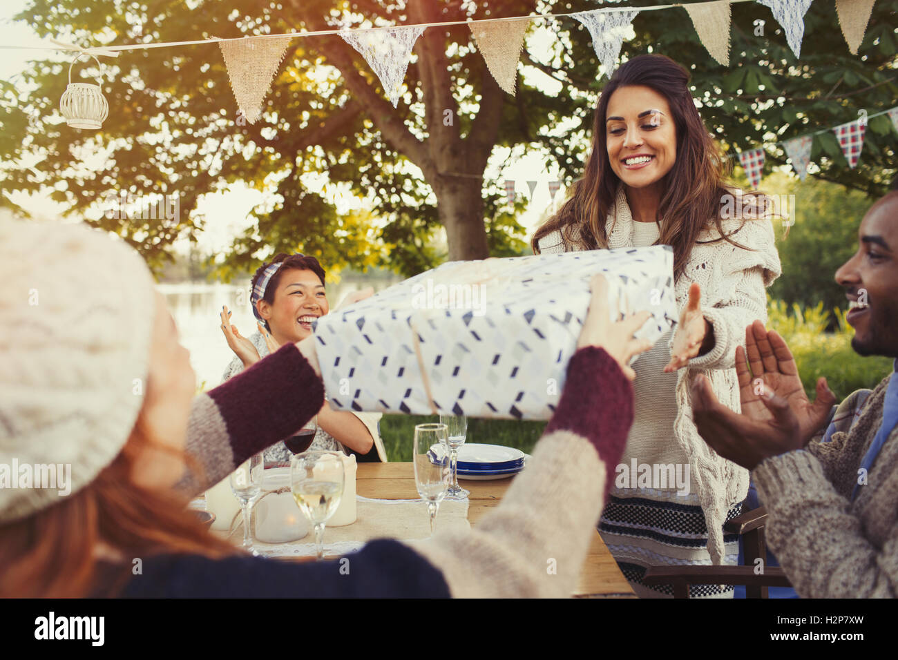 Donna ricevere regalo di compleanno a party in giardino Foto Stock