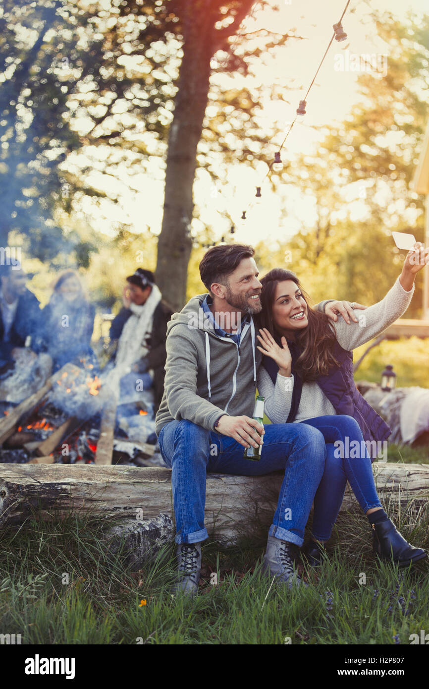 Matura in posa per selfie con la fotocamera del telefono vicino a falò Foto Stock