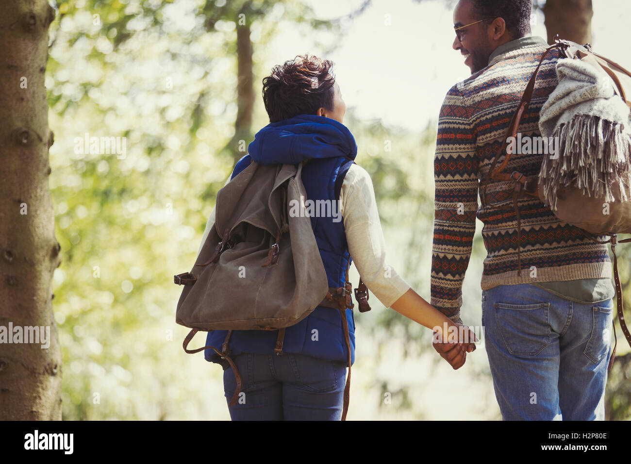 Coppia con zaini holding hands escursioni nei boschi Foto Stock