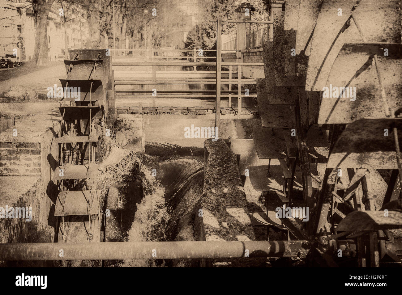 Vecchie ruote di un mulino ad acqua. In stile vintage foto. Aggiunta di grano per dare una vecchia foto effetto. Foto Stock