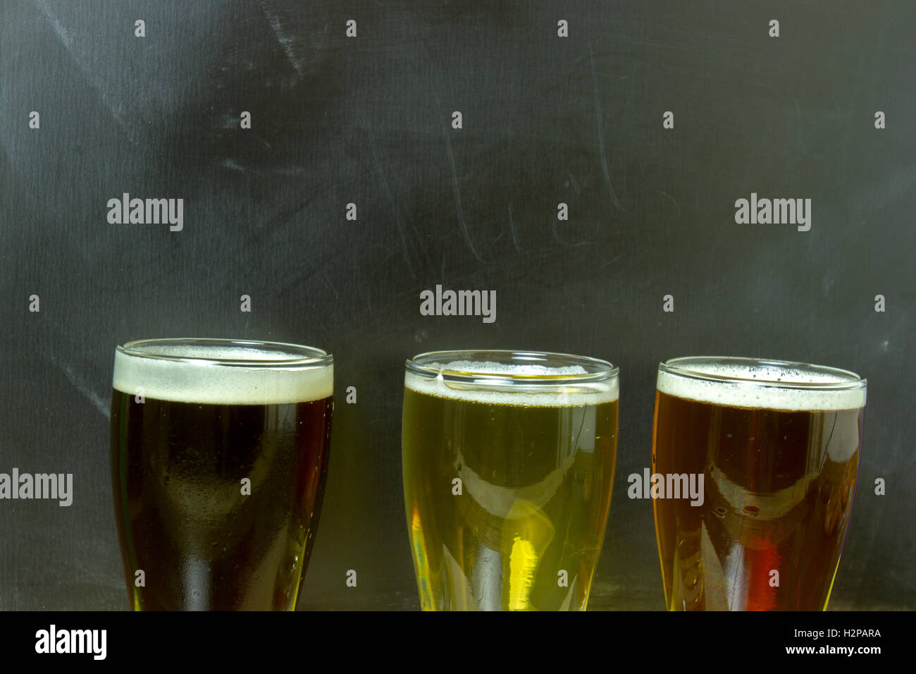 Il volo di un assortimento di birre con lavagna vuota. Foto Stock Il volo di un assortimento di birre con lavagna vuota. Foto Stock