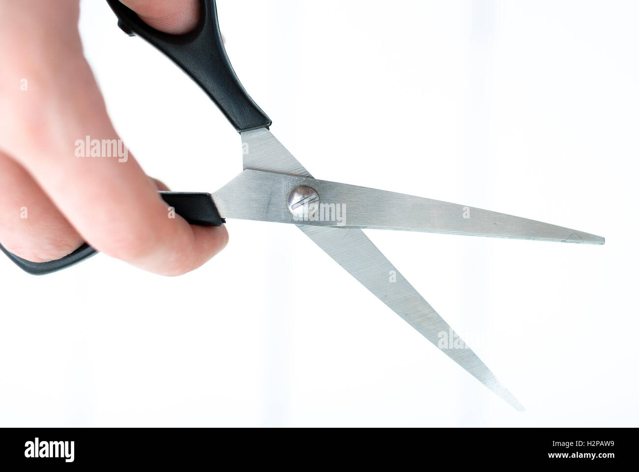 La mano impugna le forbici per assottigliare isolato su un fondo bianco Foto Stock