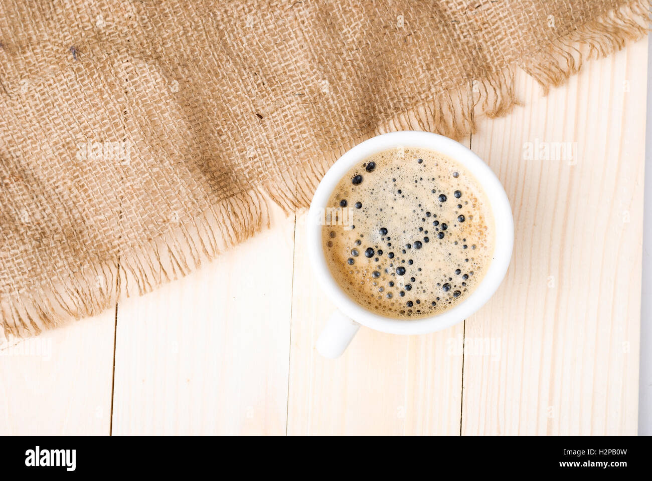 Tazza di caffè con la schiuma su un tavolo di legno Foto Stock