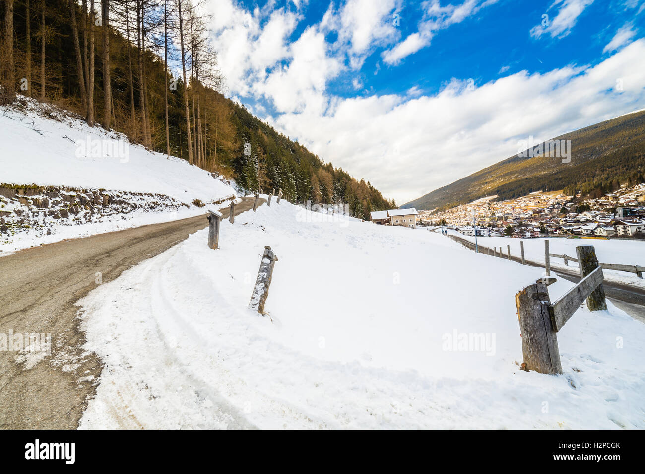 Strada di campagna che conduce attraverso un inverno paesaggio di montagna. Foto Stock