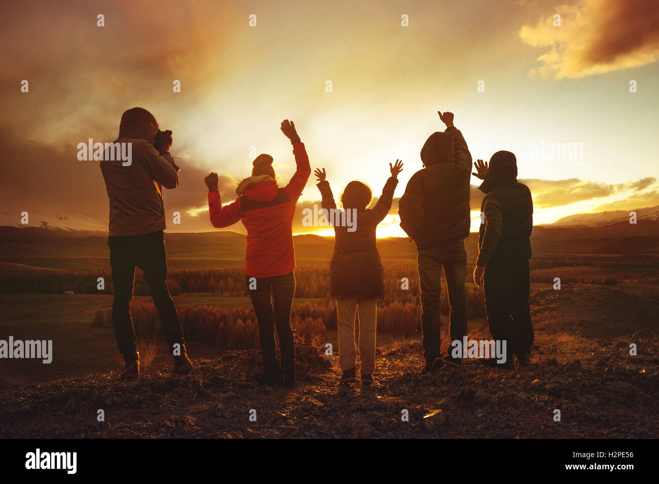 Gruppo di amici che si divertono sull sfondo al tramonto Foto Stock