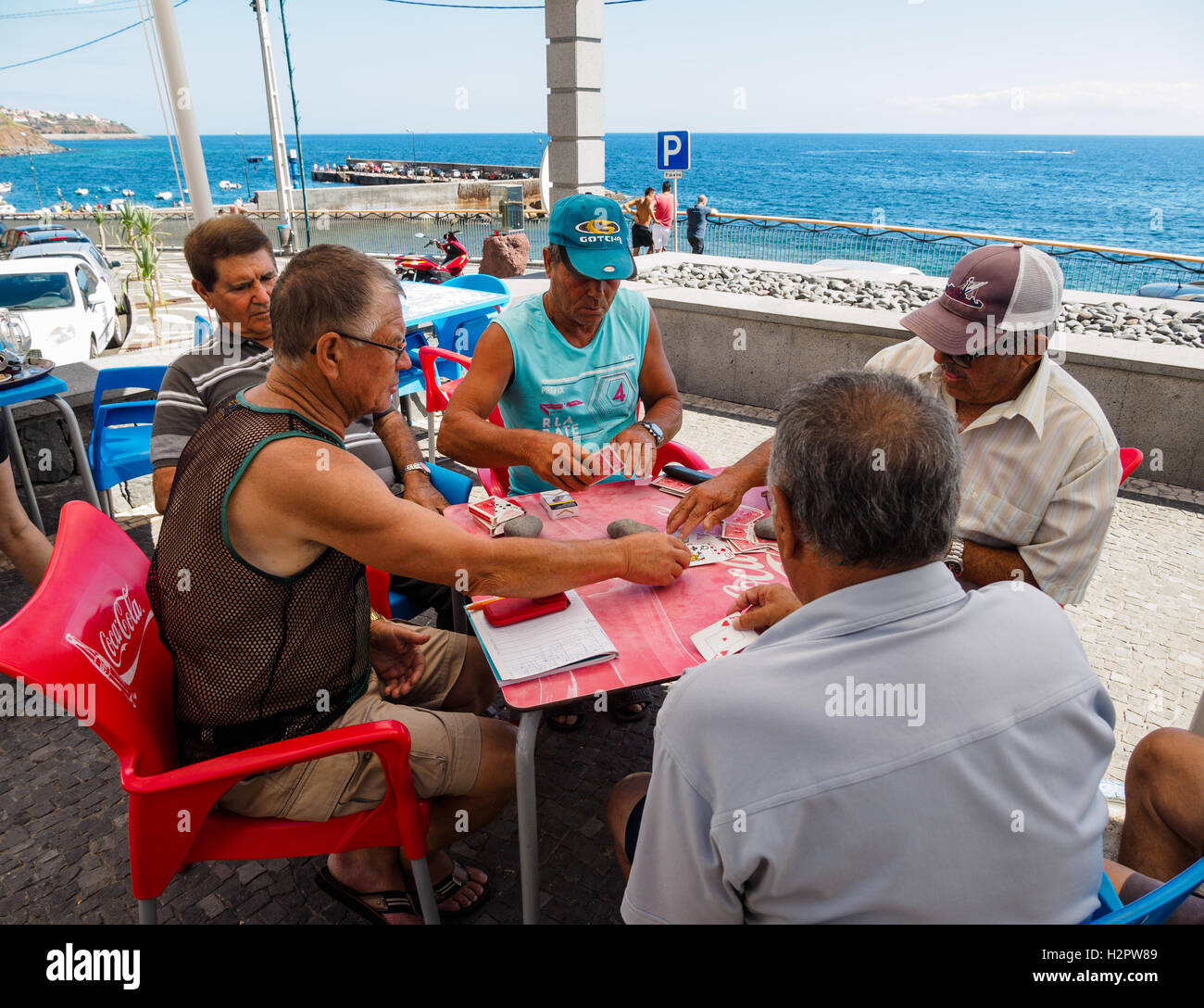 Cinque uomini godono di un gioco di carte da mare presso il villaggio di Paul do Mar Foto Stock