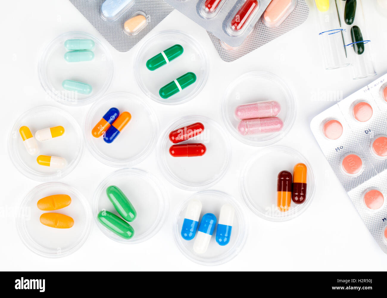 Colorate le capsule di medici in capsule di Petri. Concetto di laboratorio. Foto Stock