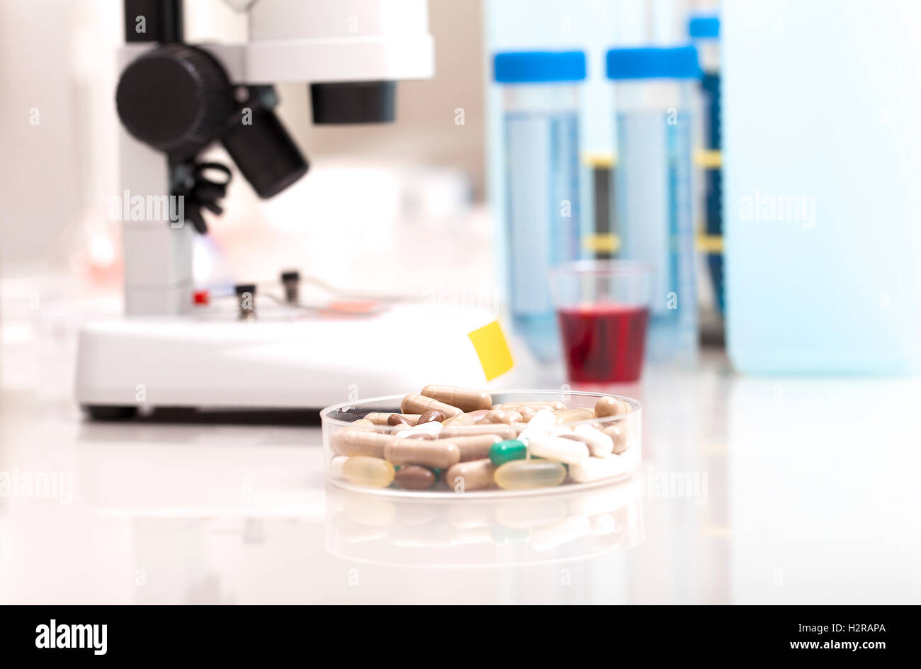 Laboratorio di Scienze sicuro di ricerca di nuovi farmaci, microscopio e pillole di rosso Foto Stock