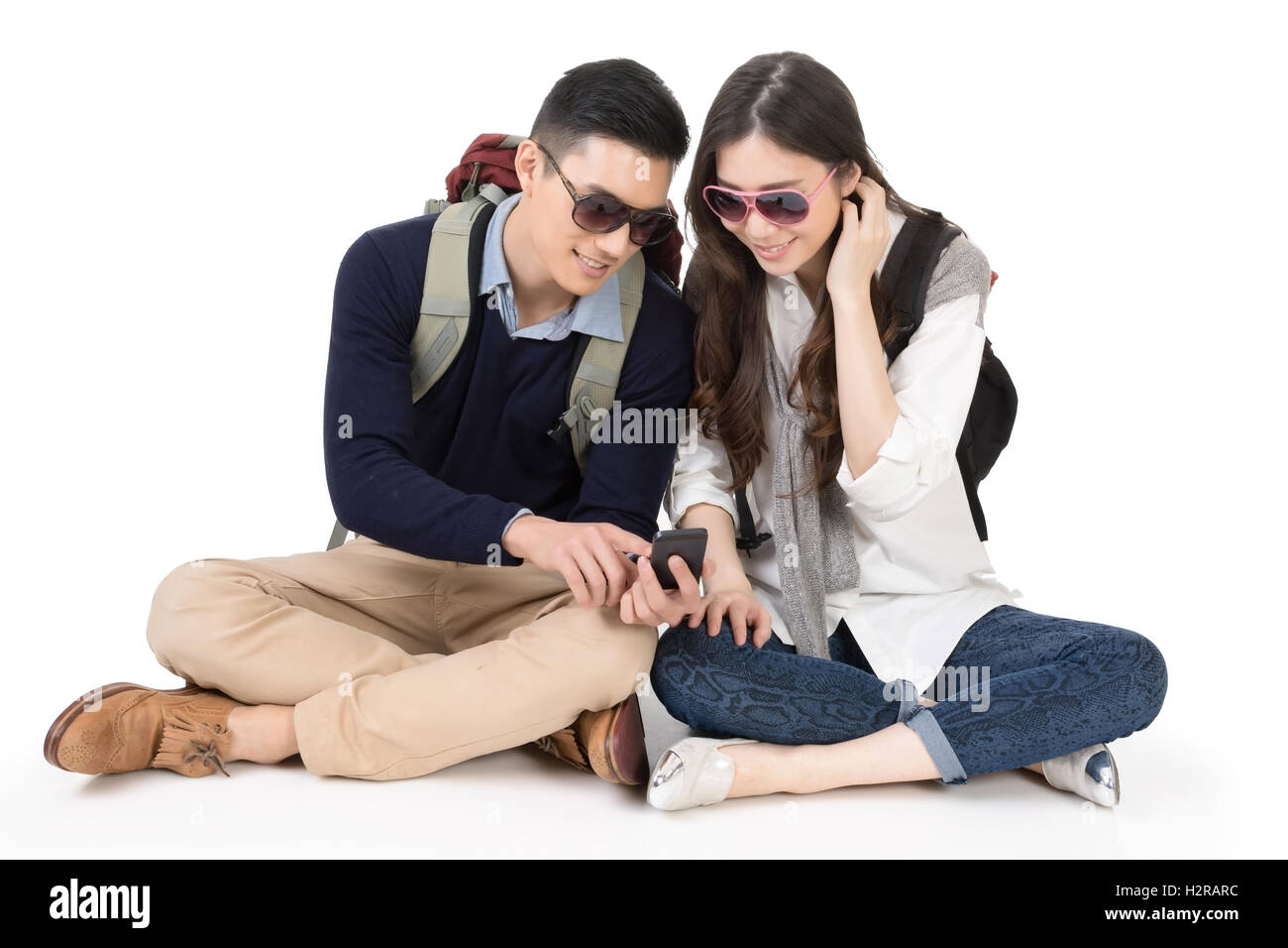 Buon viaggio Asian giovane seduto sul suolo e utilizzando cellpho Foto Stock Buon viaggio Asian giovane seduto sul suolo e utilizzando cellpho Foto Stock