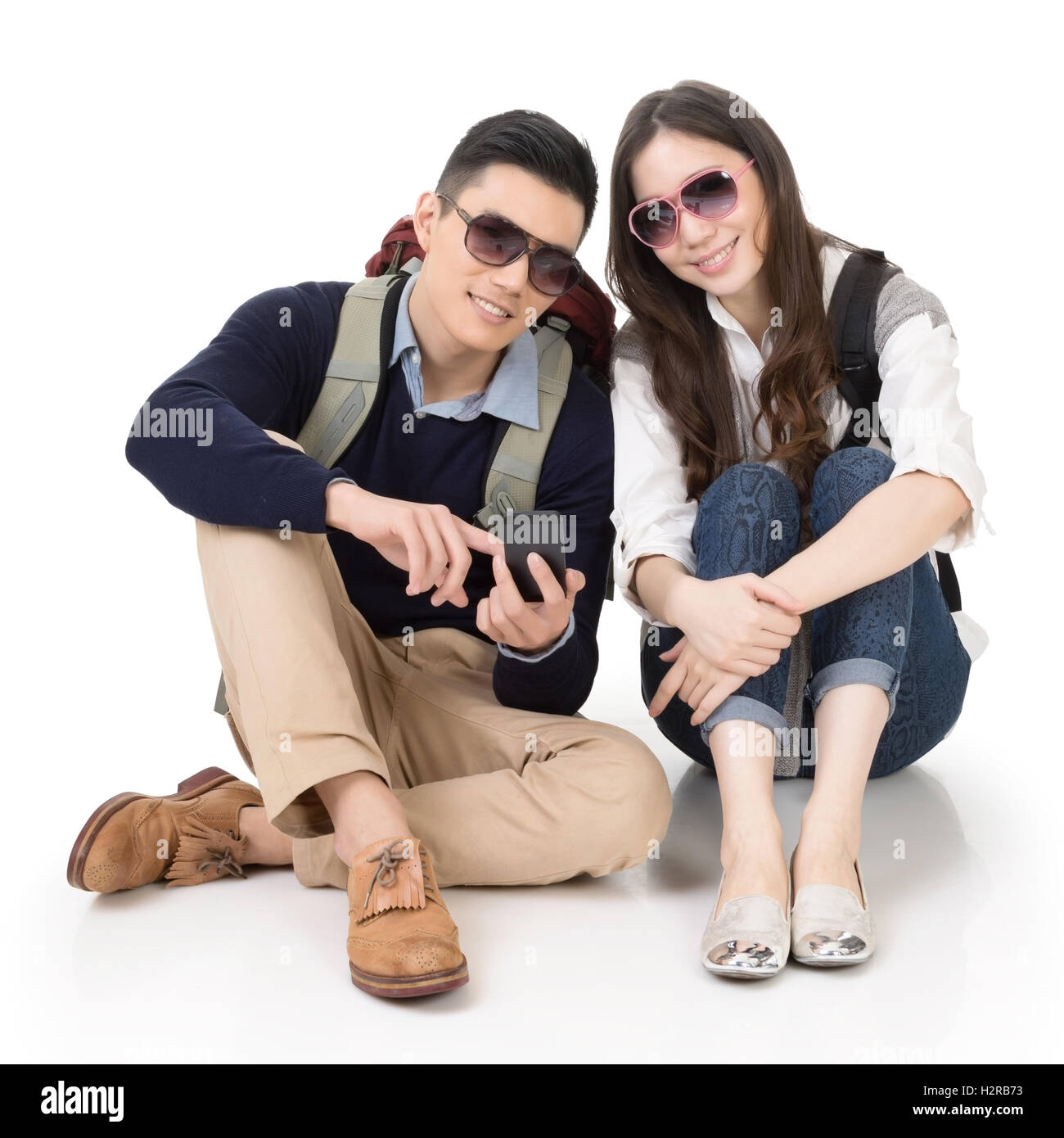 Buon viaggio Asian giovane seduto sul suolo e utilizzando cellpho Foto Stock Buon viaggio Asian giovane seduto sul suolo e utilizzando cellpho Foto Stock