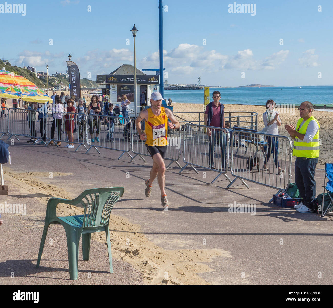 Runner e gli spettatori in occasione della annuale maratona di Bournemouth sul lungomare, West Beach in bel tempo, Dorset, Regno Unito. Foto Stock