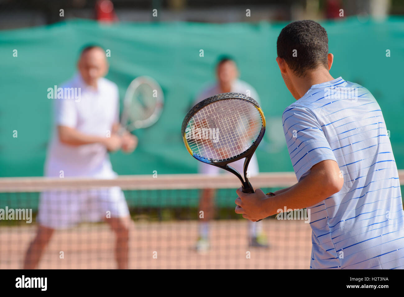 Gli uomini che giocano raddoppia il gioco di tennis Foto Stock