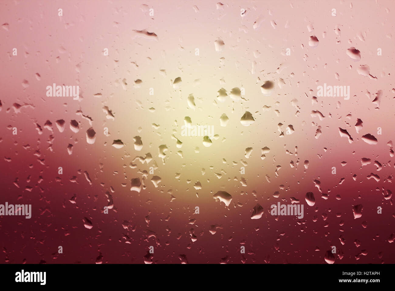 Pioggia di gocce di acqua sul vetro della finestra. Bellissimo sfondo di gocce di pioggia sul vetro al tramonto Foto Stock