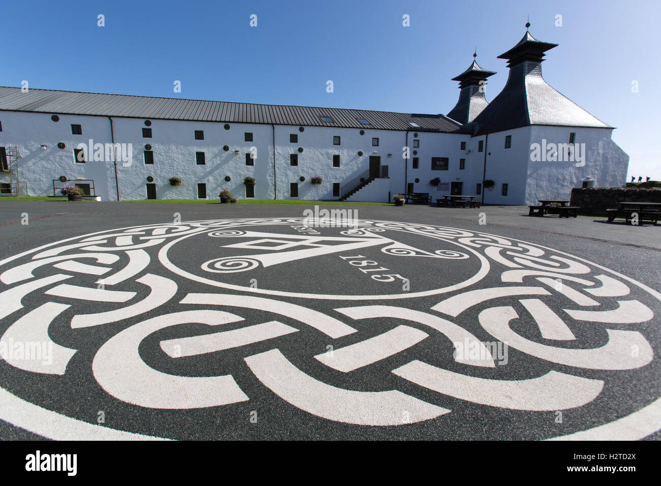 Isola di Islay, Scozia. Vista pittoresca del Ardbeg distilleria di whisky, con l'emblema Ardbeg in primo piano. Foto Stock