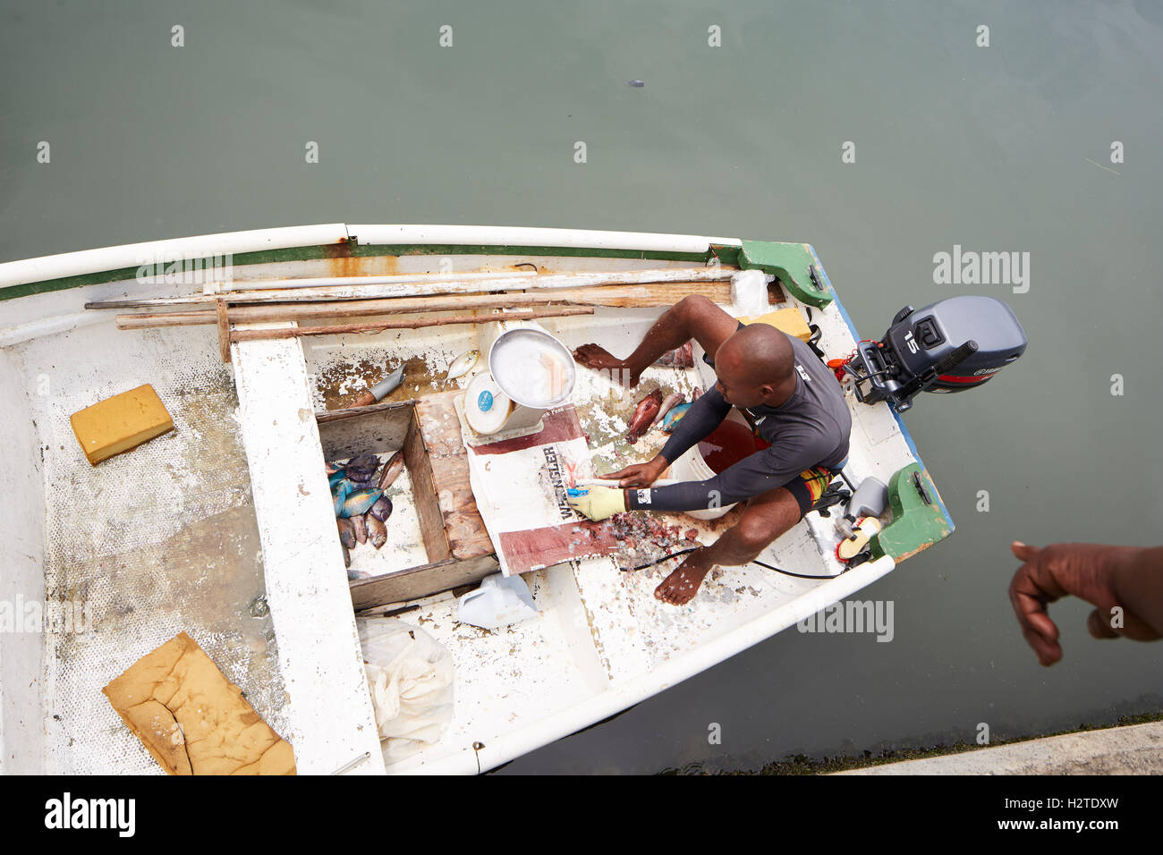 Barbados fisherman barca piccola pesca demolizione business locale trader uomo barca a remi lavoratore operaio pesce pescato poveri rundown r Foto Stock