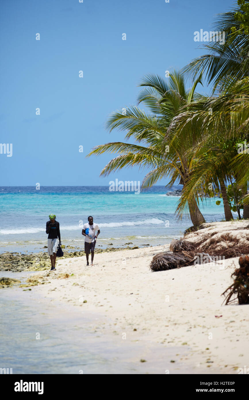 Barbados Hastings pescatore baia di spiaggia di sabbia dorata di palme passeggiate costiere pescatore aste portanti copyspace Foto Stock