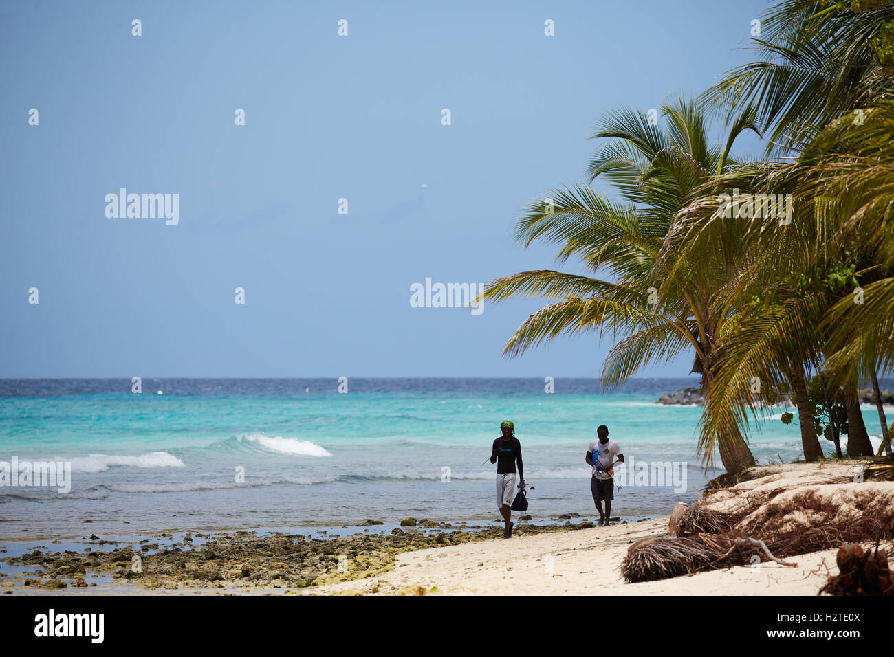 Barbados Hastings pescatore baia di spiaggia di sabbia dorata di palme passeggiate costiere pescatore aste portanti copyspace Foto Stock