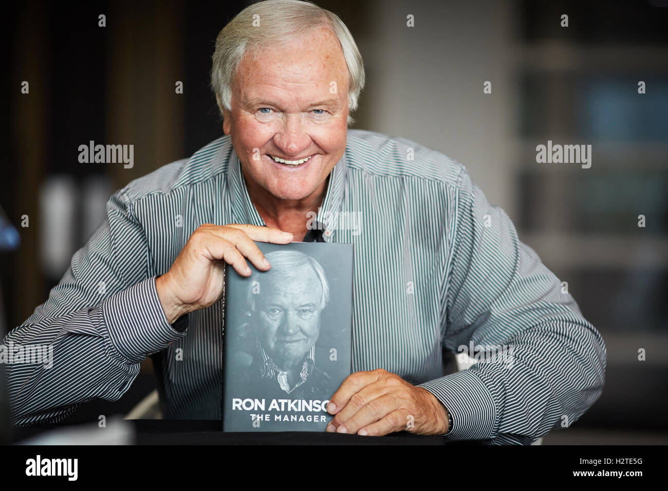 Sorridenti ritratto Ron Atkinson poste ritratto al lancio ufficiale libro firma tenendo la sua autobiografia hardback Foto Stock
