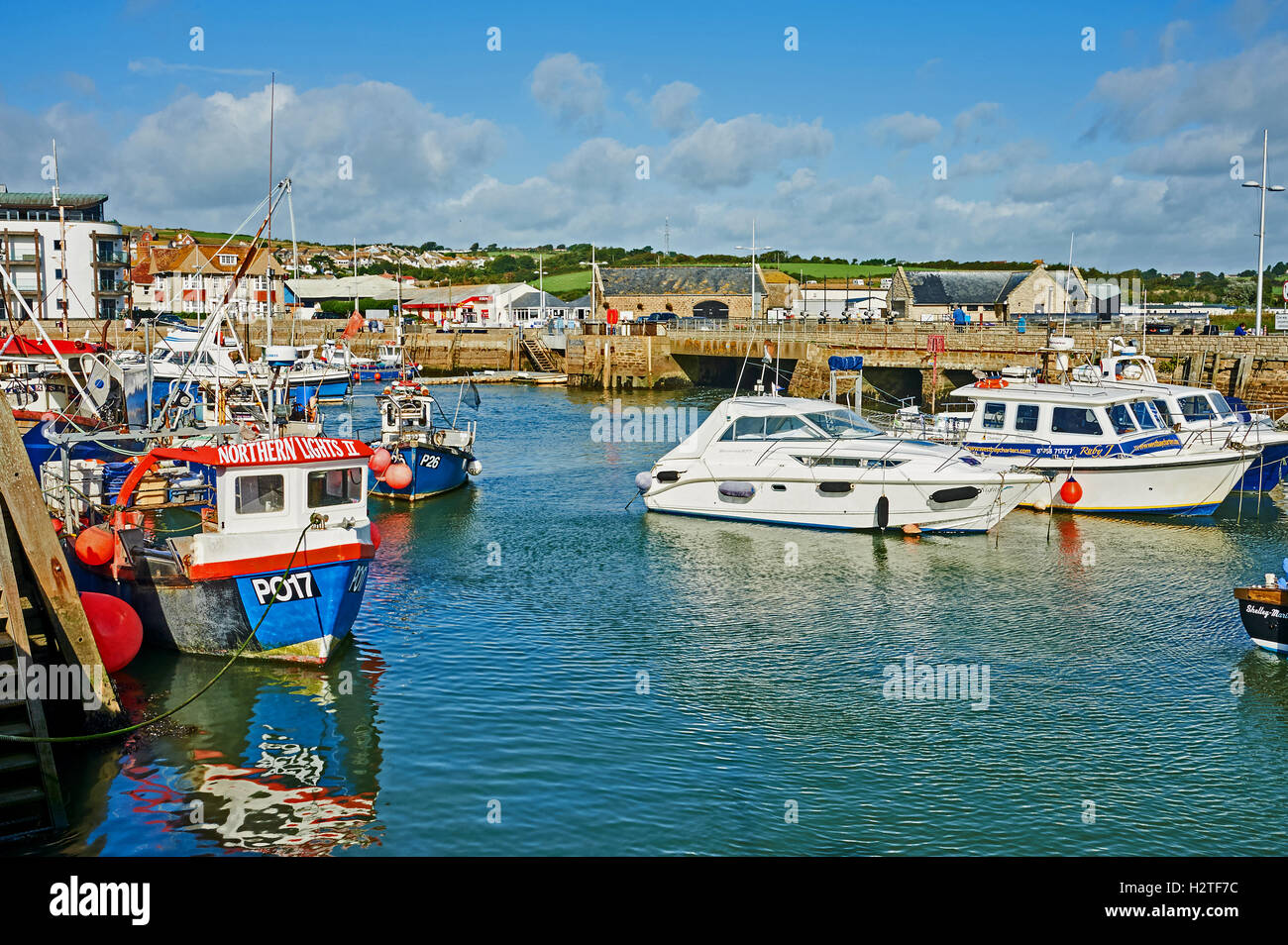 West Bay nel Dorset è un piccolo porto di lavoro visto qui con un mix di lavoro barche da pesca. Il piccolo porto è stato centrale per la serie Broadchurch. Foto Stock