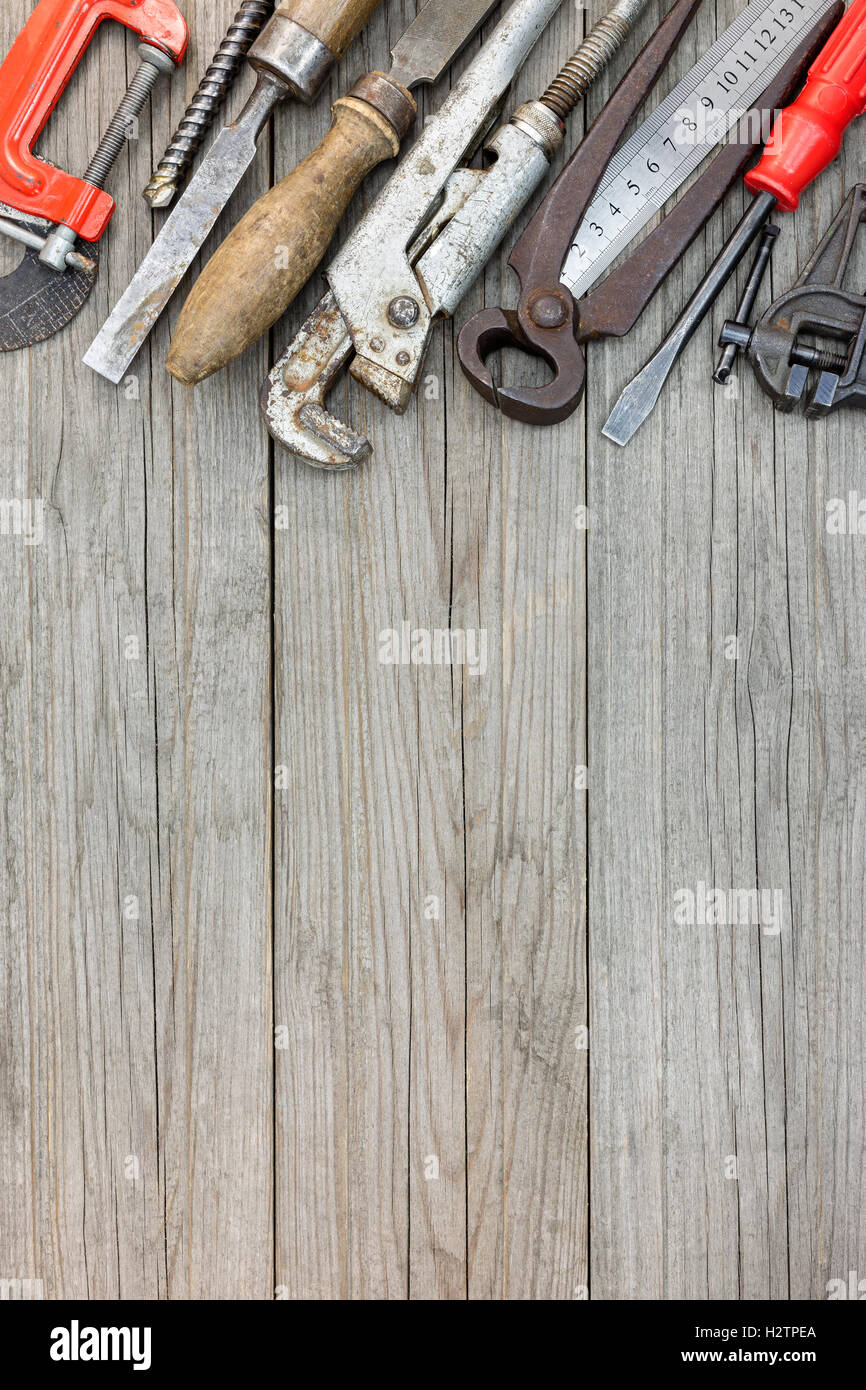 Vecchio arrugginito gli strumenti a mano e lo strumento sul tavolato in legno sfondo di superficie Foto Stock