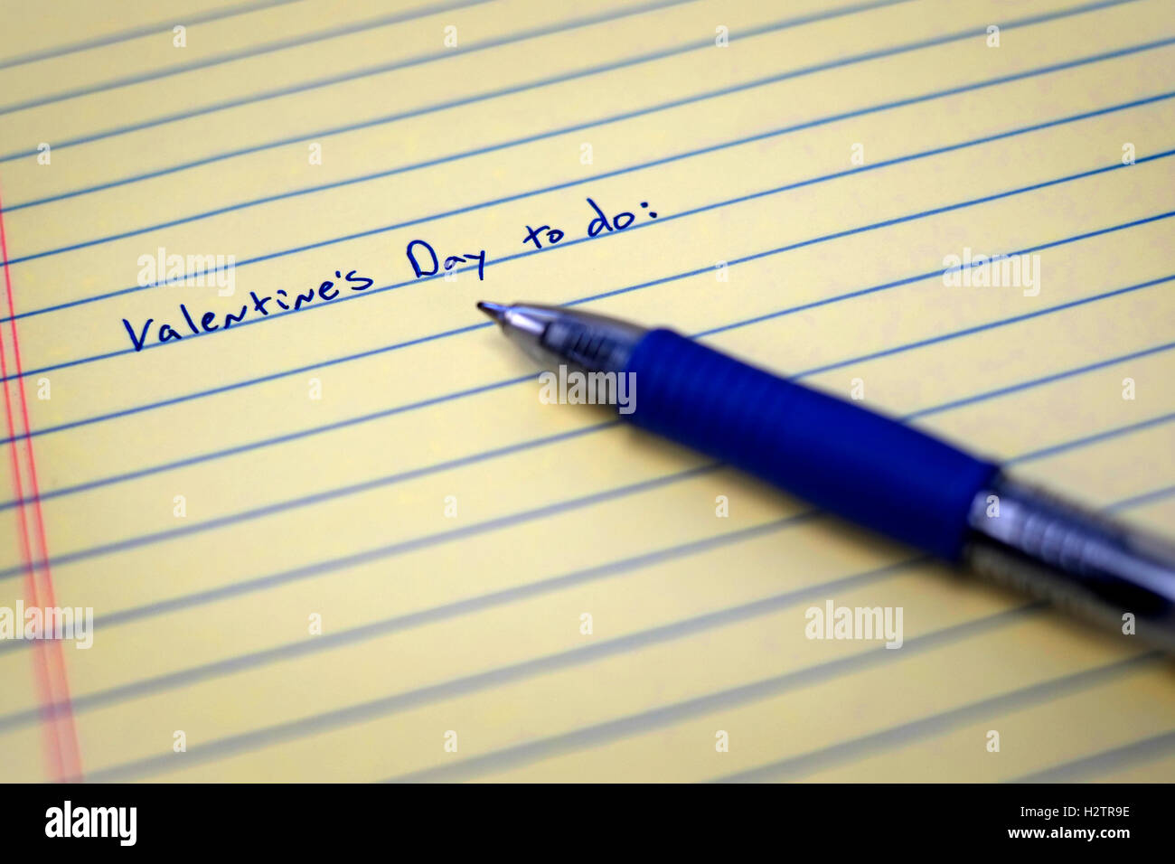 Vista dettagliata del giorno di San Valentino Lista da fare su un foglio di carta con una penna blu scrittura scritta Foto Stock