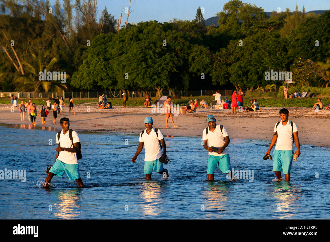 Hotel lavoratori a piedi nella spiaggia di Tamarin, Mauritius. Relection nell'acqua. Foto Stock