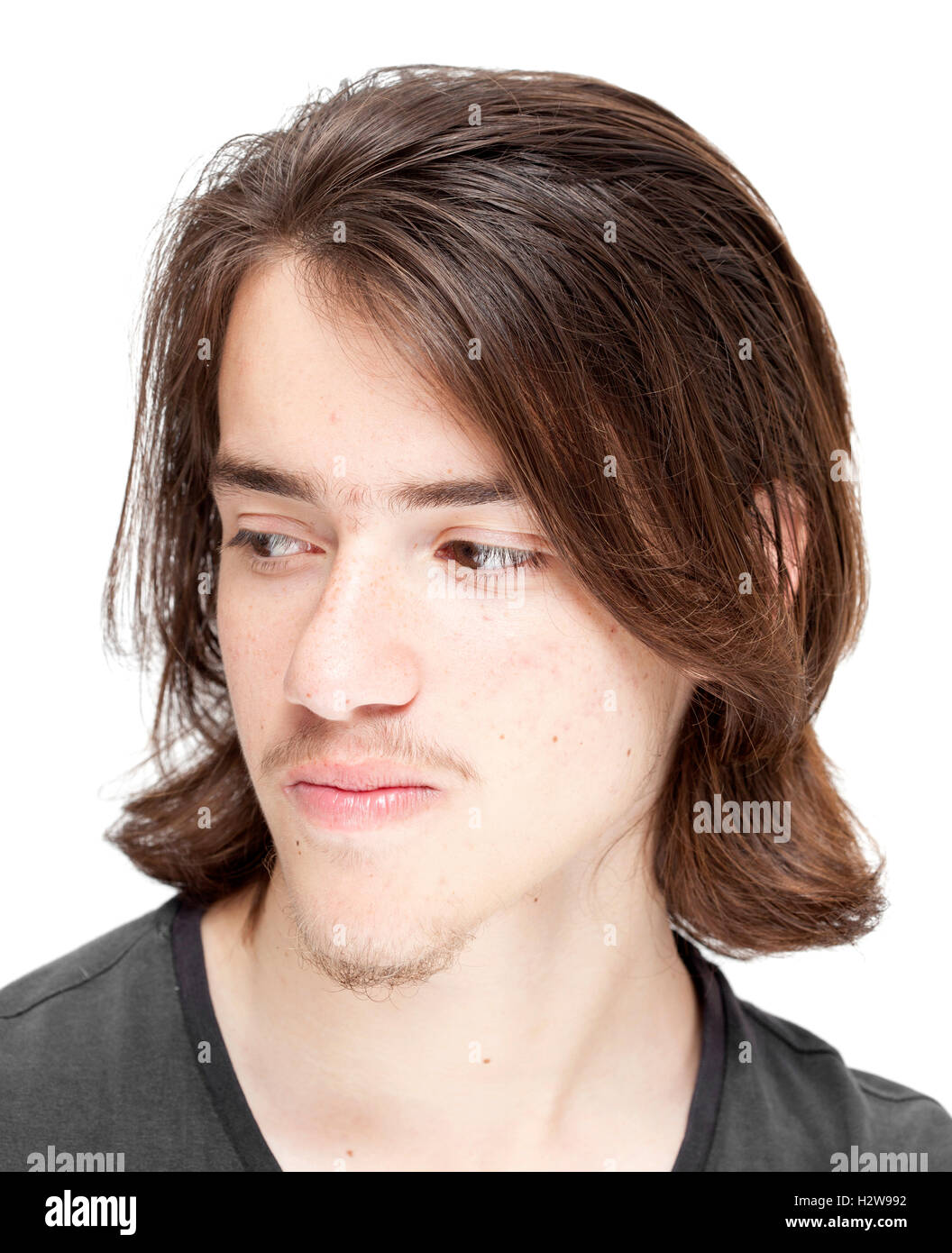 Ragazzo adolescente con lunghi capelli scuri isolati su sfondo bianco Foto Stock