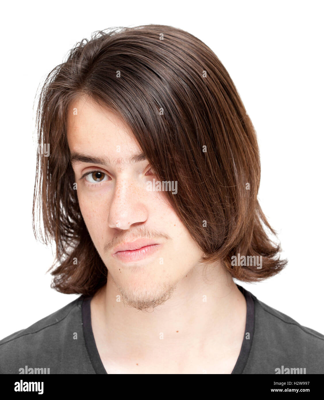 Ragazzo adolescente con lunghi capelli scuri isolati su sfondo bianco Foto Stock