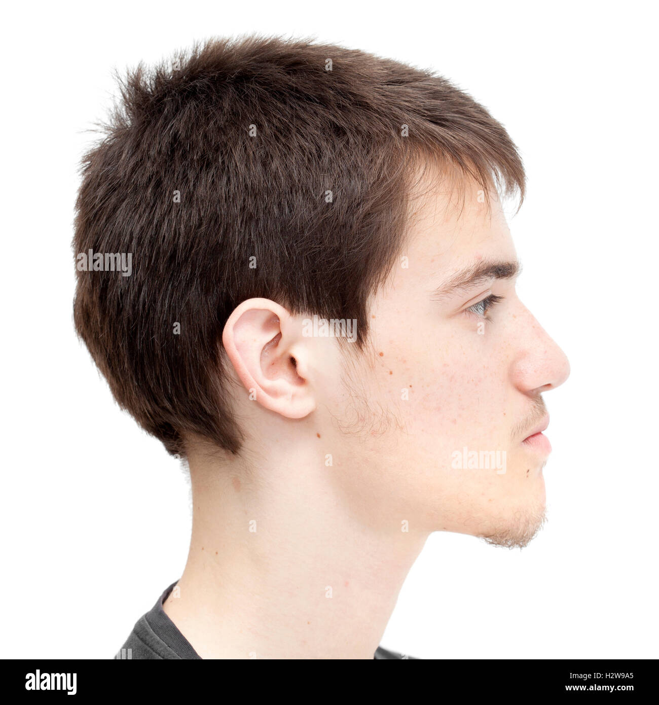 Ragazzo adolescente con corti capelli scuri isolato su bianco Foto Stock