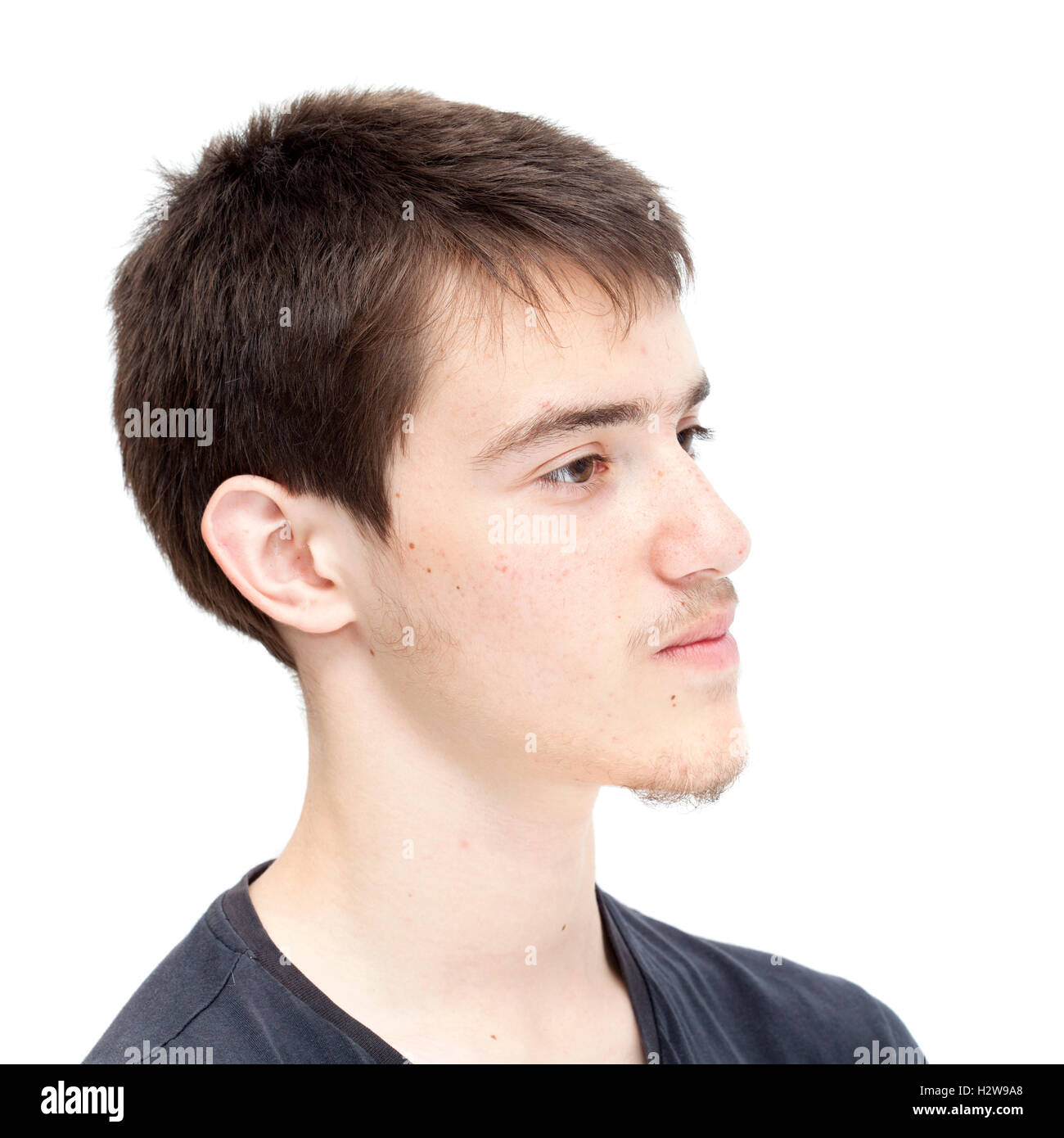Ragazzo adolescente con corti capelli scuri isolato su bianco Foto Stock