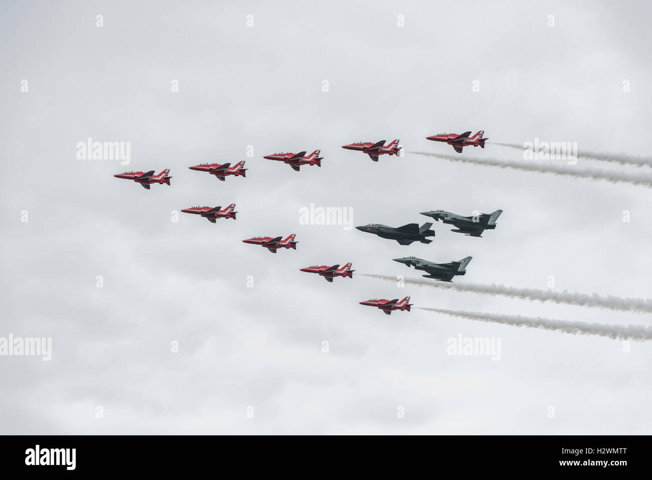 Il Regno Unito è di nuovo 5a generazione stealth fighter jet il Lockheed Martin F-35B Lightning II vola in formazione con le frecce rosse Foto Stock
