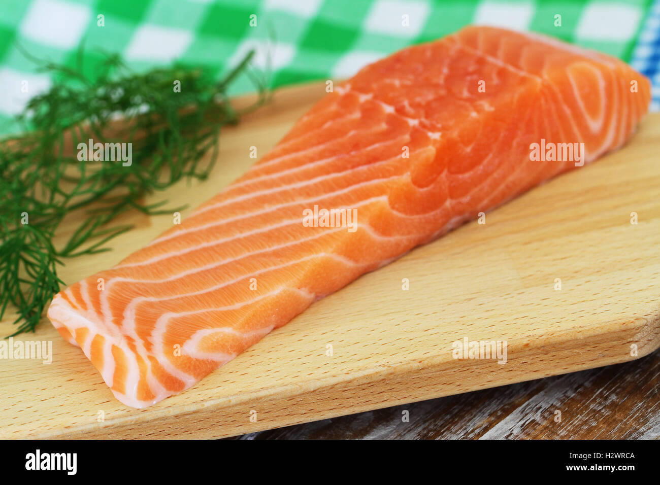 Raw bistecca di salmone su tavola di legno con aneto fresco Foto Stock