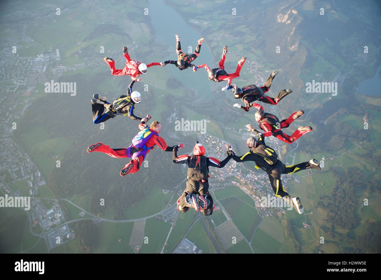 Nove skydivers formano una stella di formazione su Gruyères in Svizzera Foto Stock