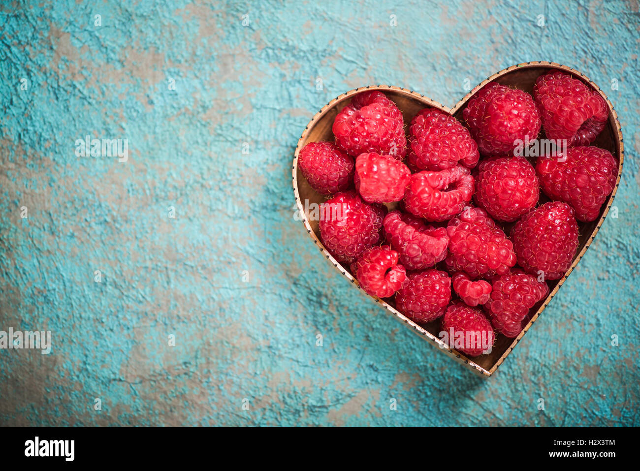 Lamponi in forma di cuore simbolo, amore per la frutta e uno stile di vita sano concetto Foto Stock