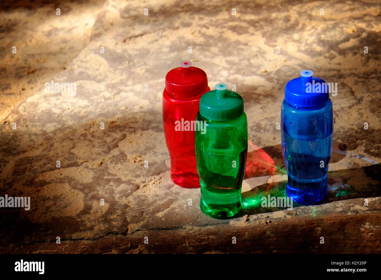 Dettagliato il rosso, il verde e il blu bottiglie su ruvide rocce Foto Stock