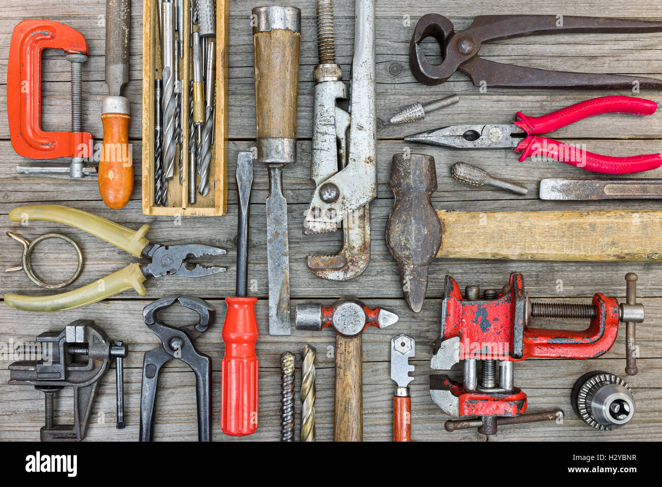 Set di vecchio arrugginito strumenti e hardware per il lavoro manuale su legno grigio sfondo tabella Foto Stock