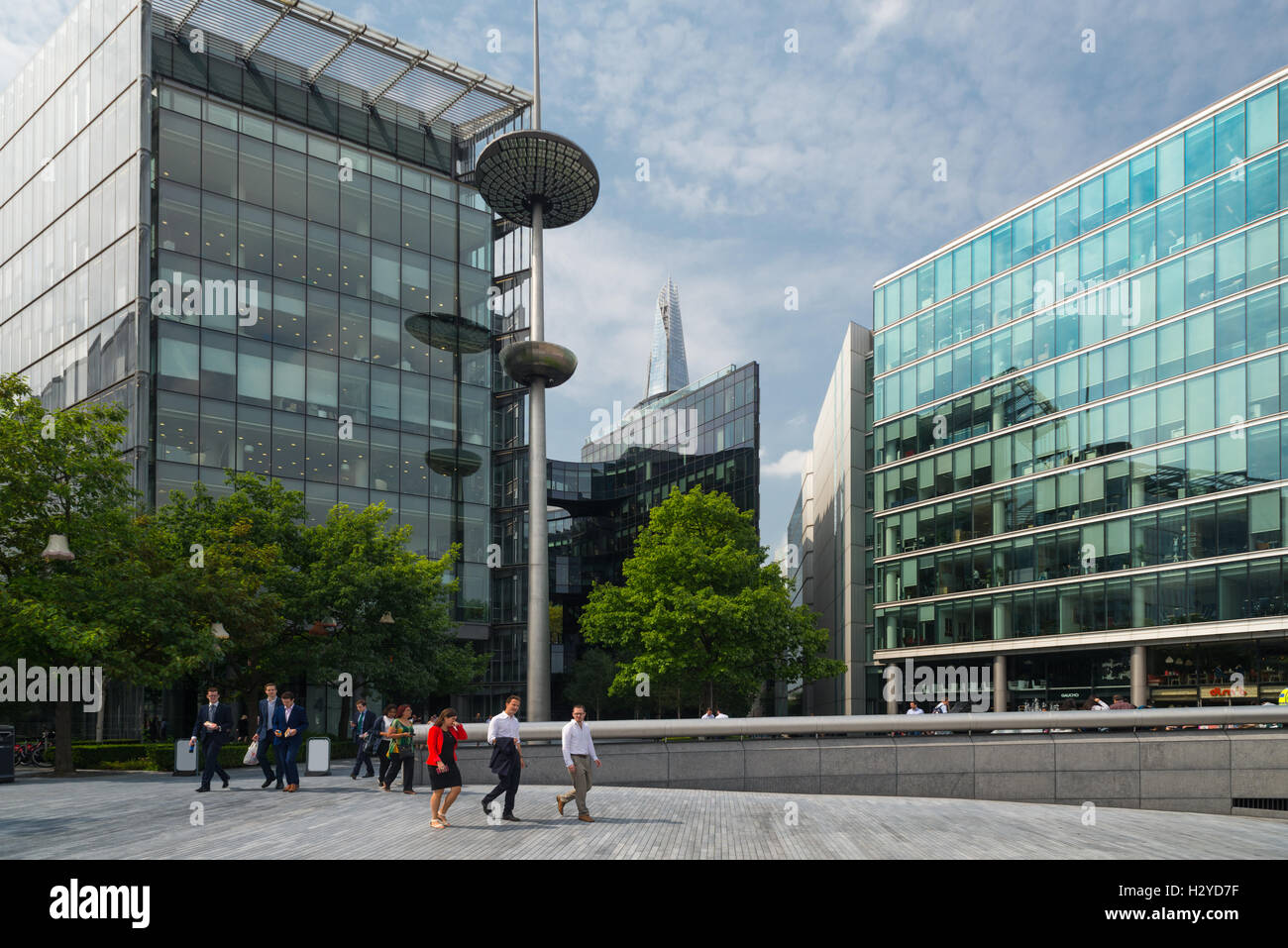 Le persone di fronte all'ufficio di edifici di più Londra Riverside e il grattacielo di Shard in estate, London, Regno Unito Foto Stock