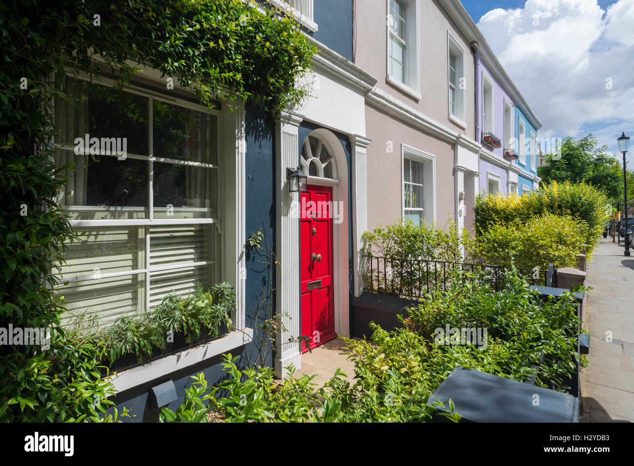 Colorati e incolto facciate di case rosso con sportello frontale a Portobello Road a Notting Hill in estate, London, Regno Unito Foto Stock