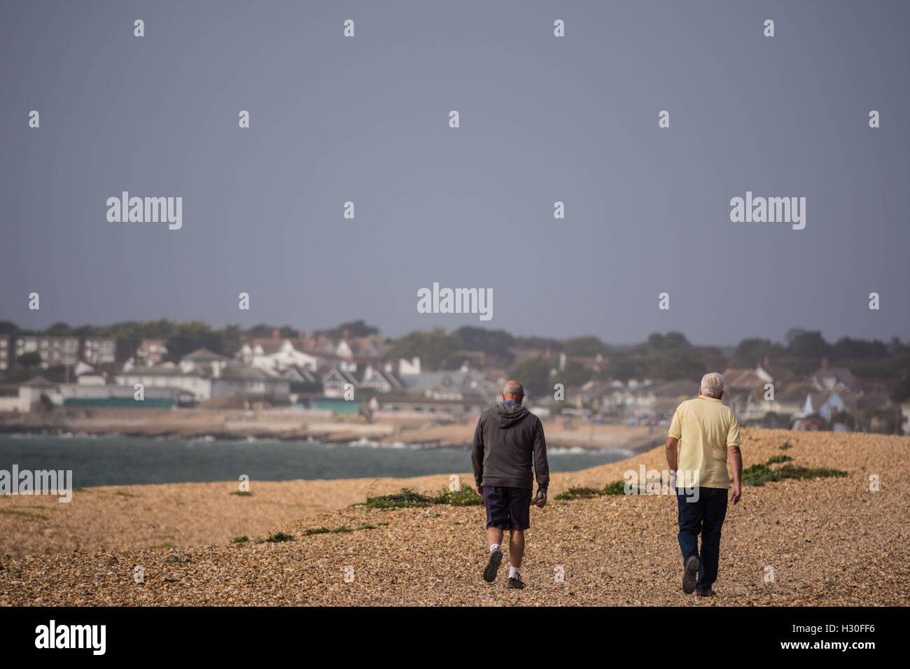 Due uomini anziani camminare insieme su una spiaggia. Foto Stock