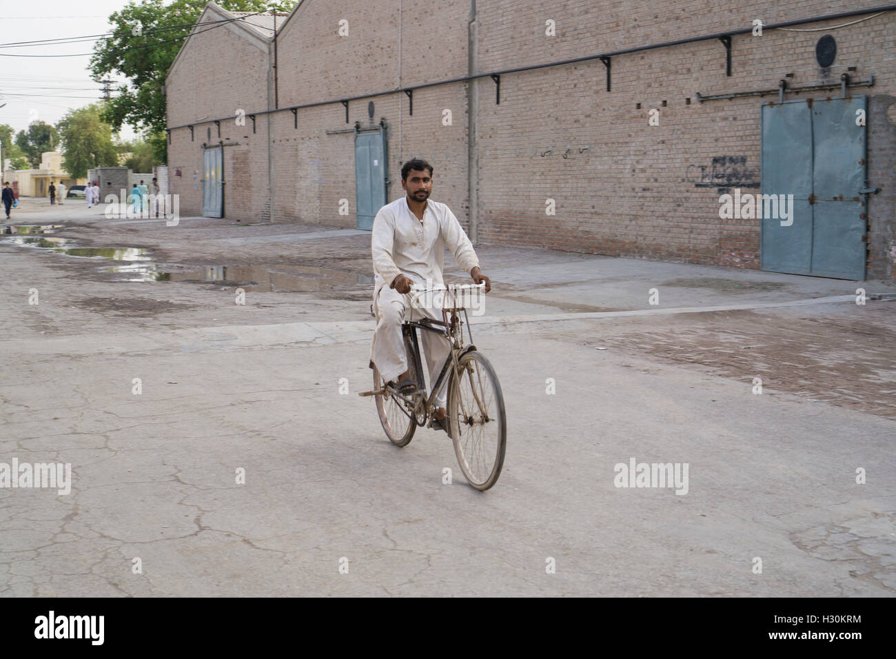 Uomo pakistano in sella alla sua bicicletta Multan Pakistan Foto Stock