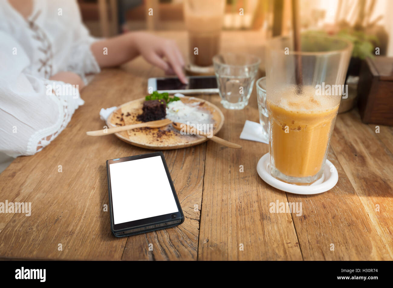 Telefono cellulare con la zona vuota sul touch screen sulla tavola in legno rustico in cafe. Fine settimana stile di vita con il concetto di tecnologia Foto Stock