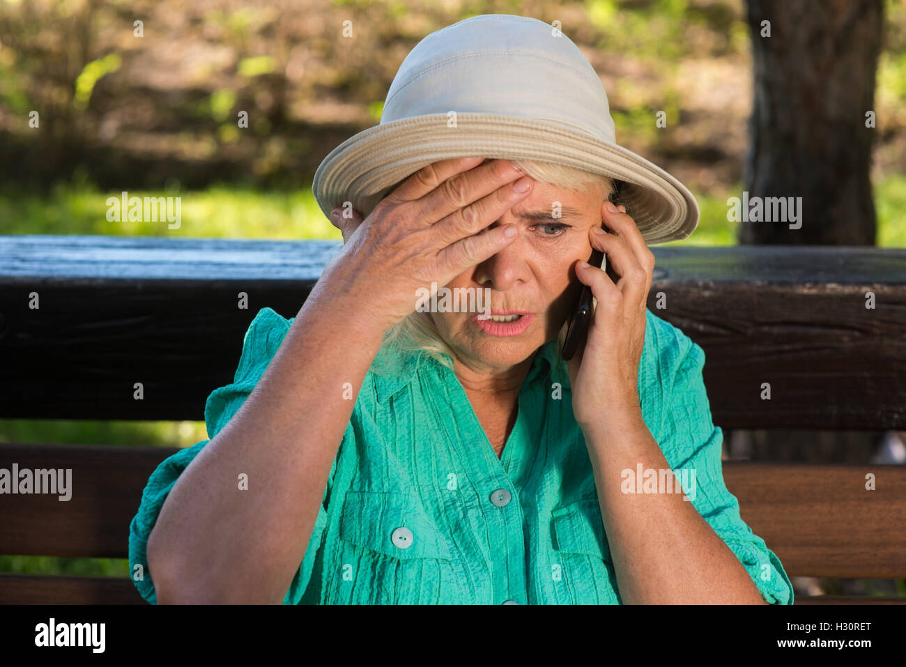 Spaventata donna con un telefono cellulare. Foto Stock